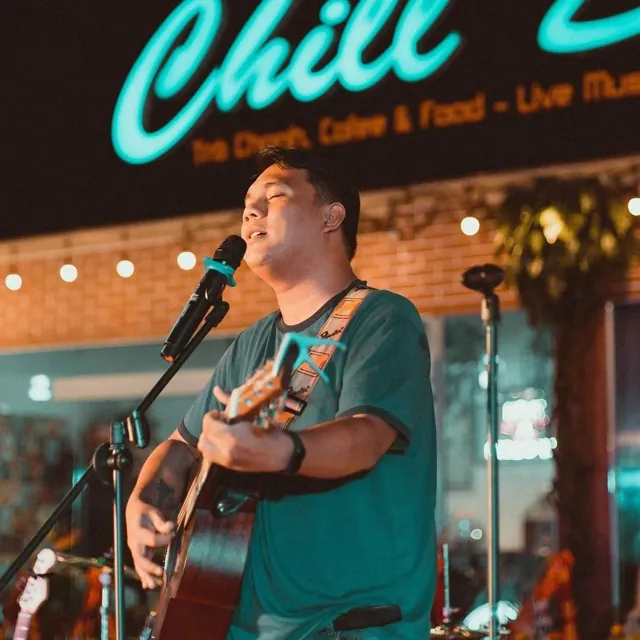 Ralph singing and playing guitar in a café